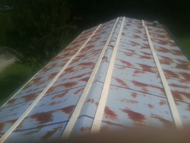 Rusted metal roof panels with new wood purlins before replacement — Storm Damage Roof Repair in Ocoee by Roofing Brothers