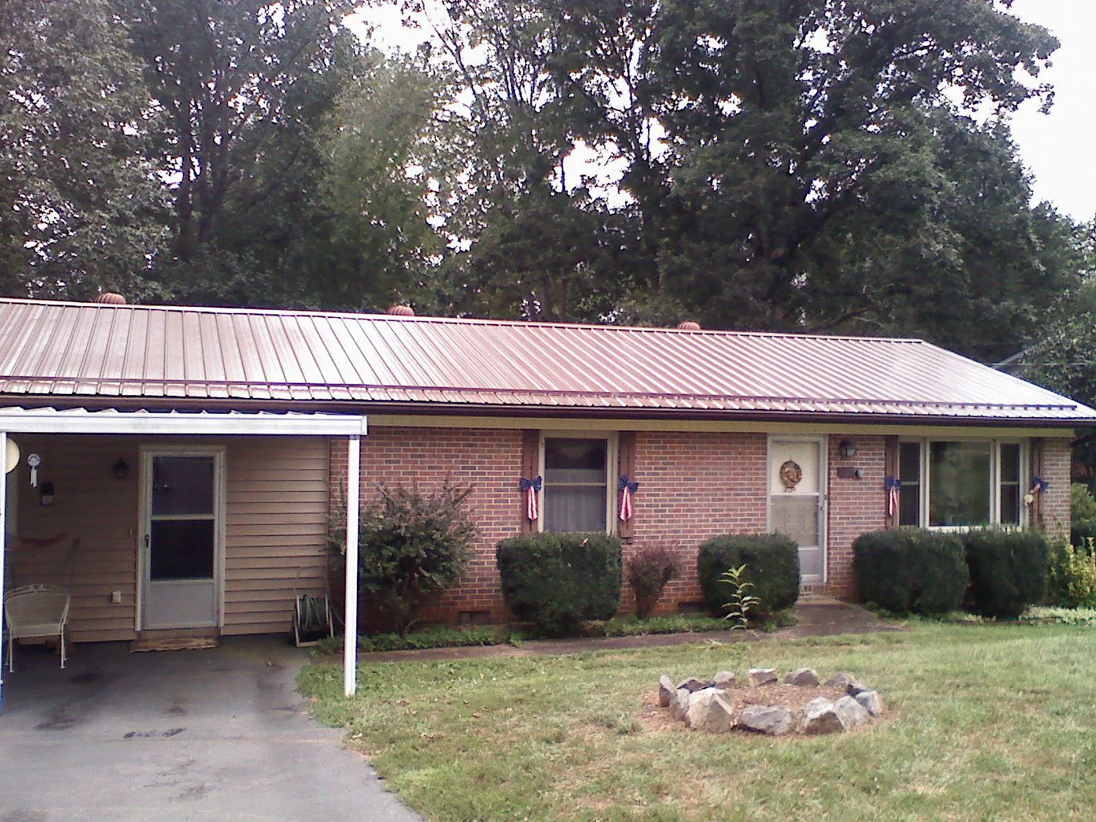 Bronze metal roof and carport on a brick ranch home — Roof Repair work by our crew in Ocoee