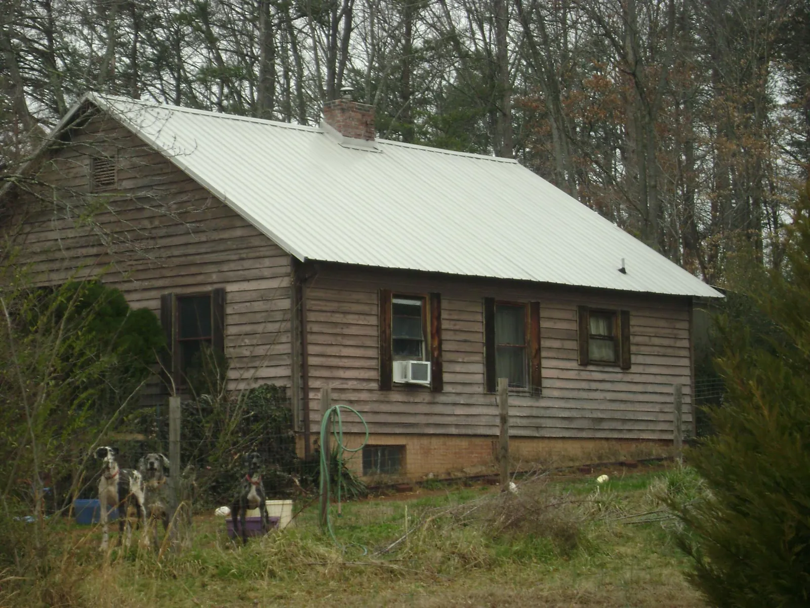 White metal roof on an old wood sided farmhouse, from a Metal Roof Installation job in Ocoee